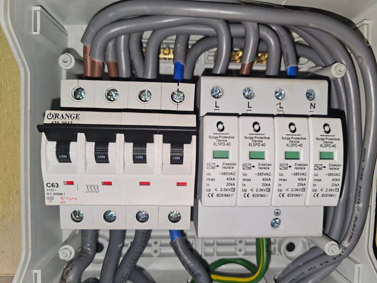 Interior of an AC combiner box with a four-pole 63 A breaker and four surge protective devices